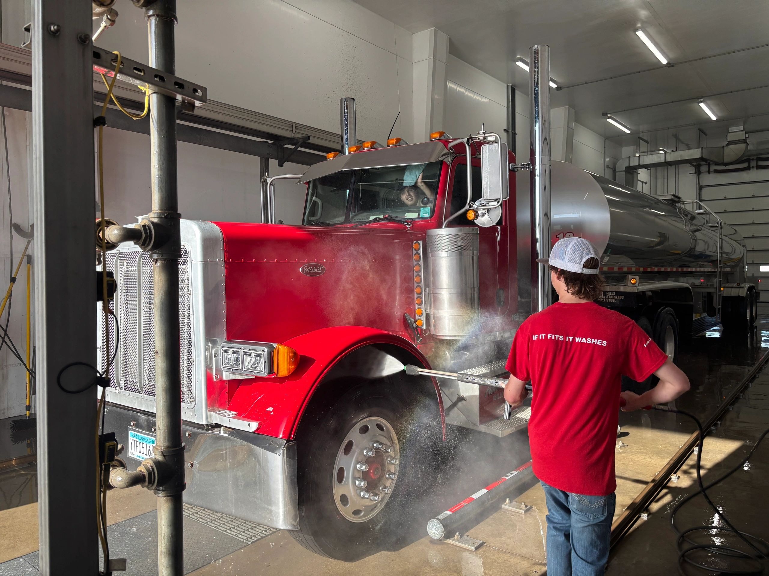 Worker washing truck with high pressure water spray